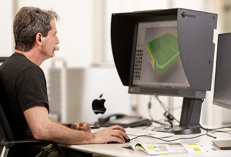 Ein Mann sitzt vor einem Monitor mit 3D-Modell, symbolisch für 3D Rendering - n c ag
