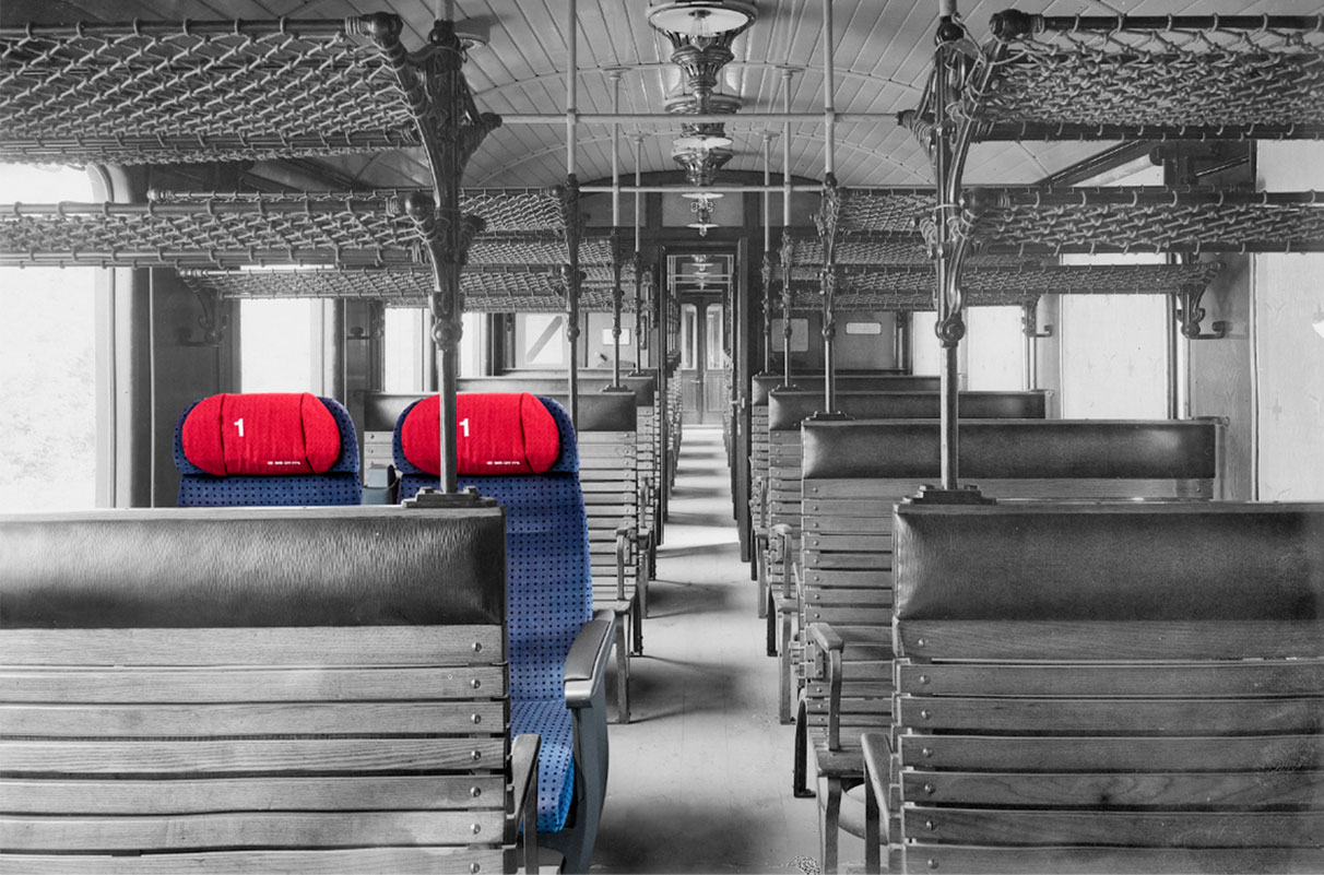 An old train compartment in black and white with two modern seats in color, symbolic of image editing - n c ag