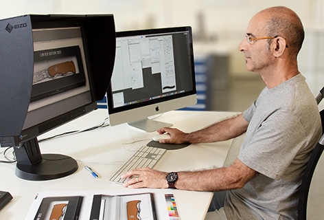 Ein Mann sitzt vor einem Monitor und bearbeitet Bilder, symbolisch für Bildbearbeitung - n c ag
