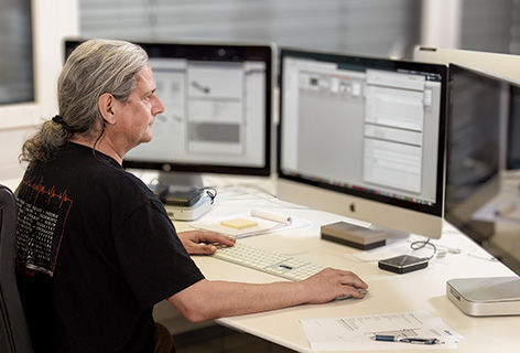 Ein Mann bearbeitet Produktdaten mit einer Software am Bildschirm, symbolisch für Product Information Management - n c ag