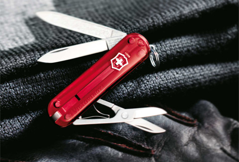 An unfolded pocket knife on black fabric, emblematic of the customer Victorinox - n c ag