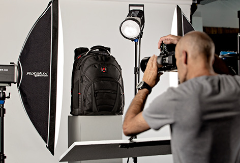 Ein Fotograf fotografiert einen Rucksack im Studio, symbolisch für Produktfotografie - n c ag
